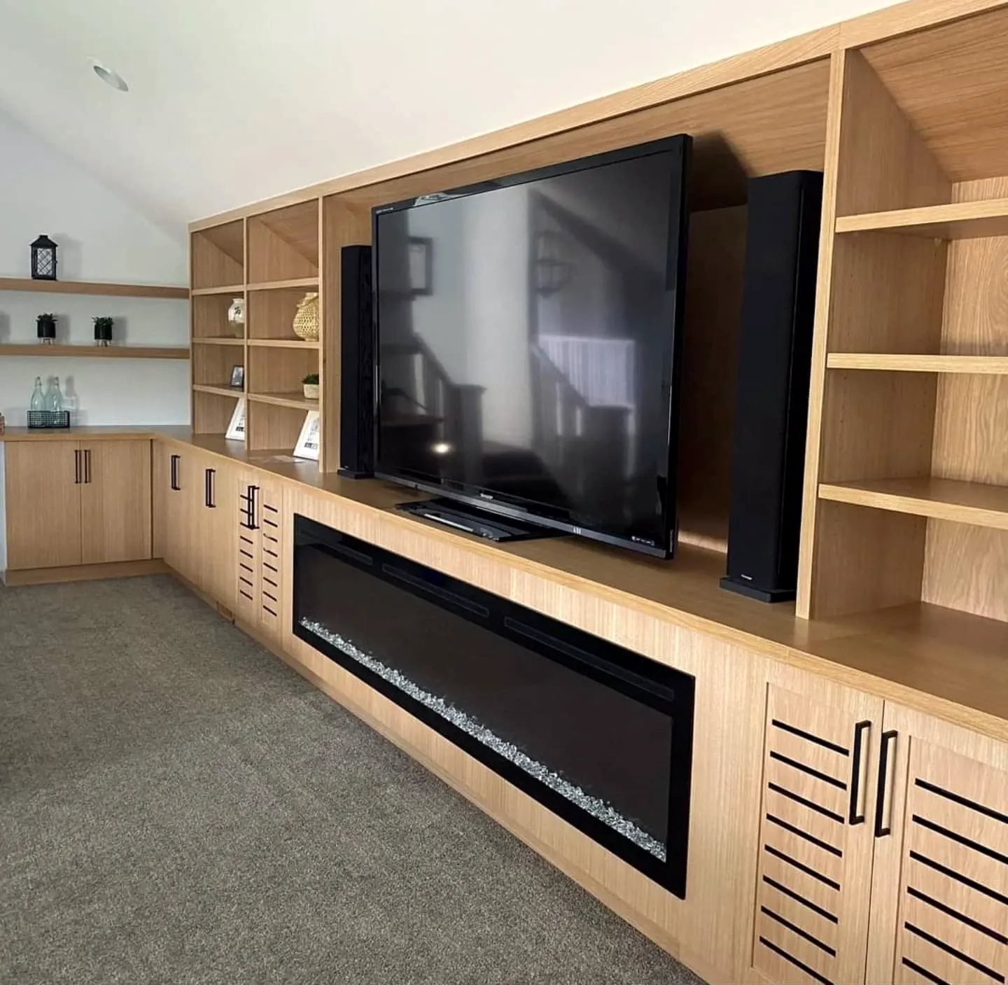 Media wall with fireplace, woodgrain cabinets and open shelves