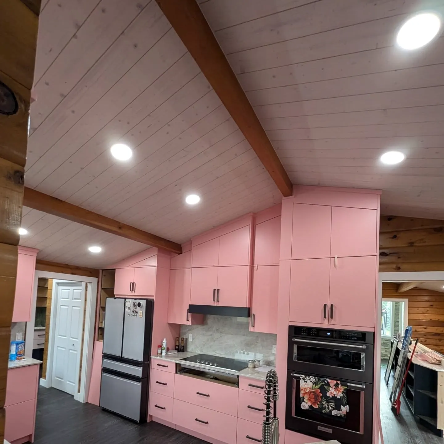 Pink kitchen under a vaulted pine ceiling
