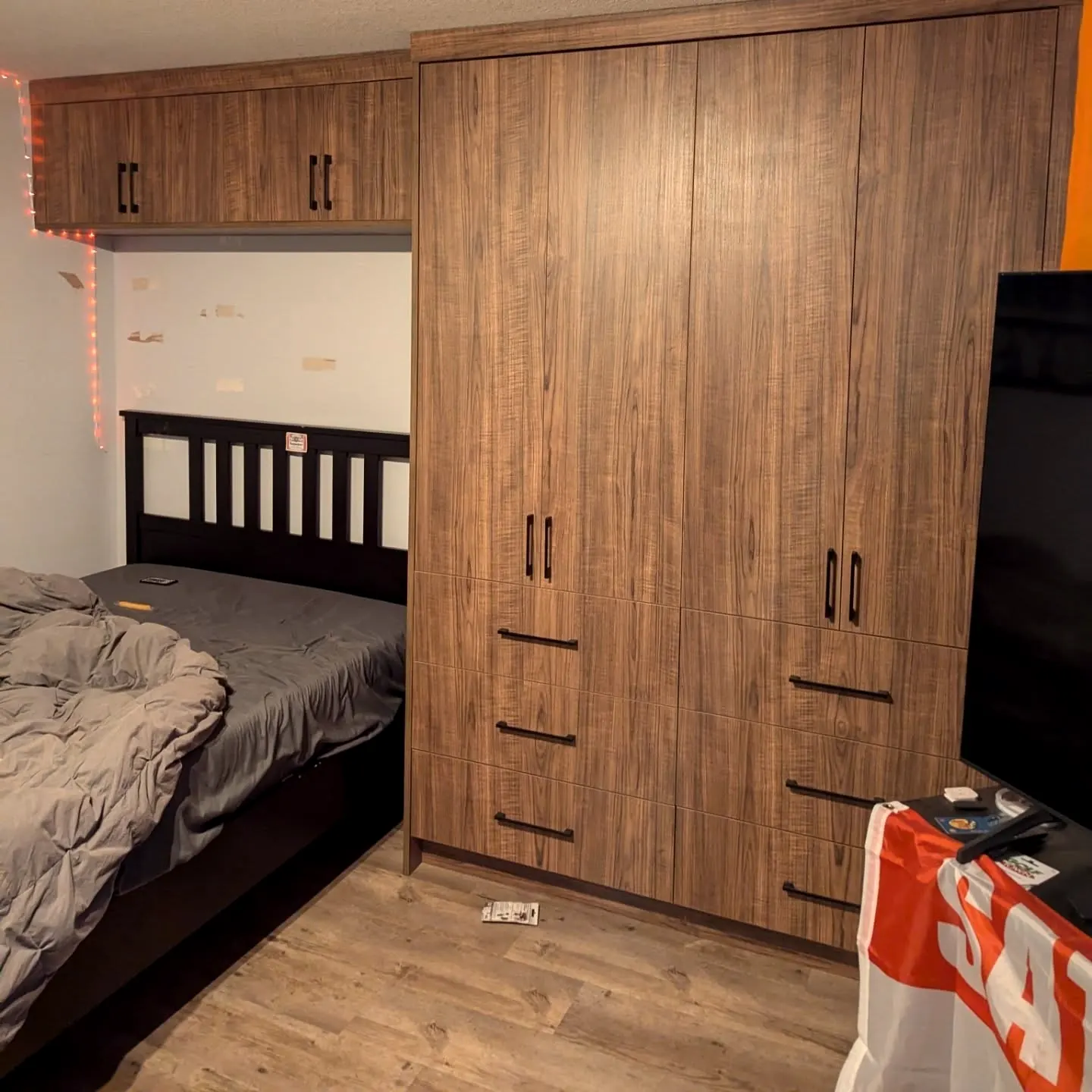 Woodgrain wardrobe wall around a bed