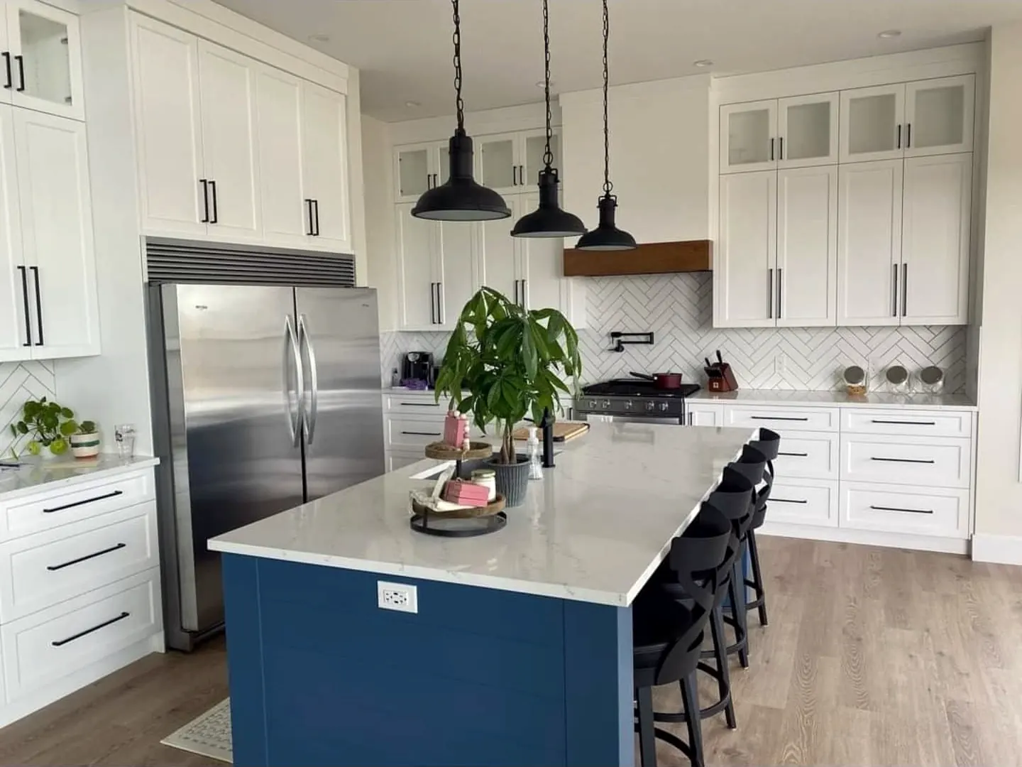 White shaker kitchen with a navy island and pendant lights