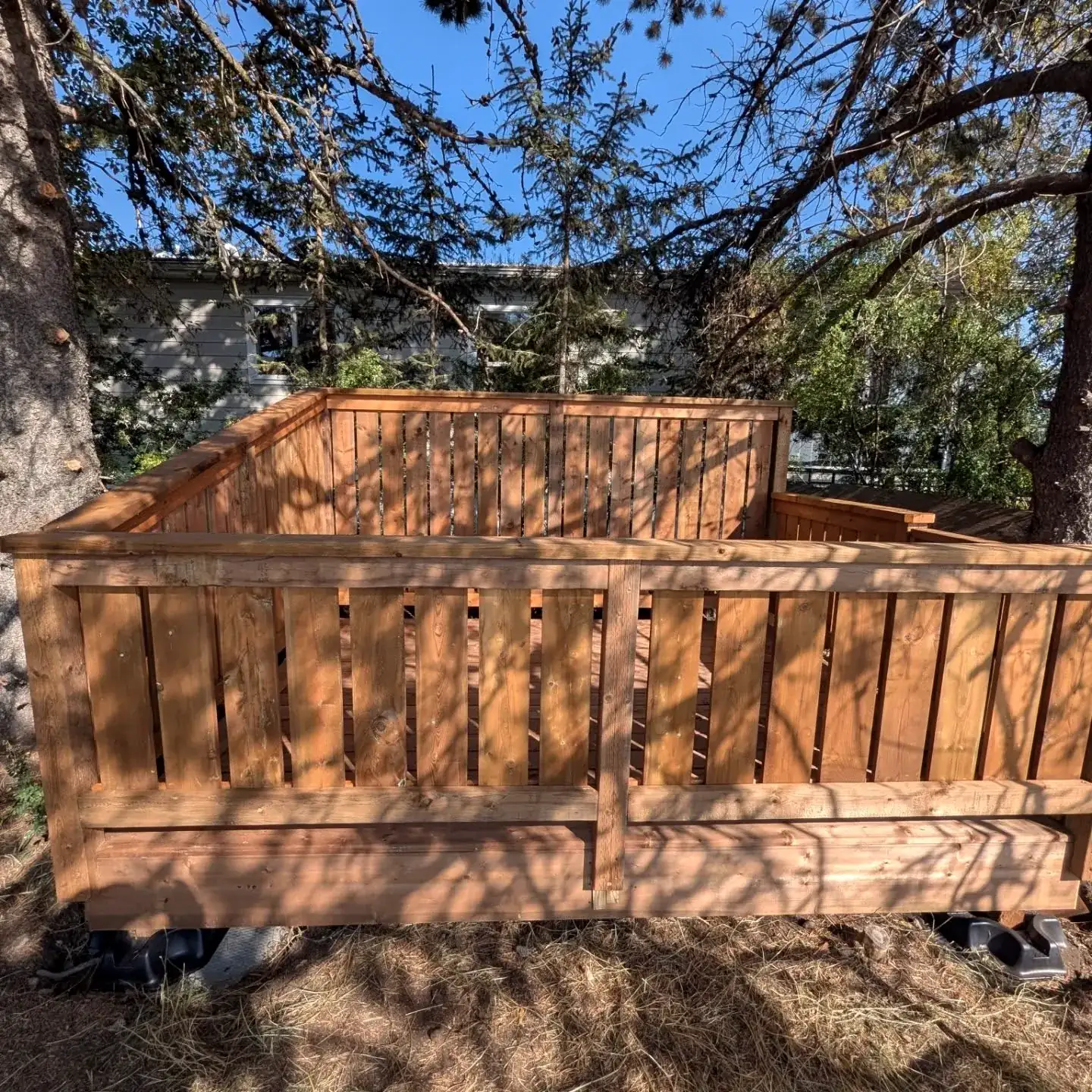 Stained deck and railing under the trees