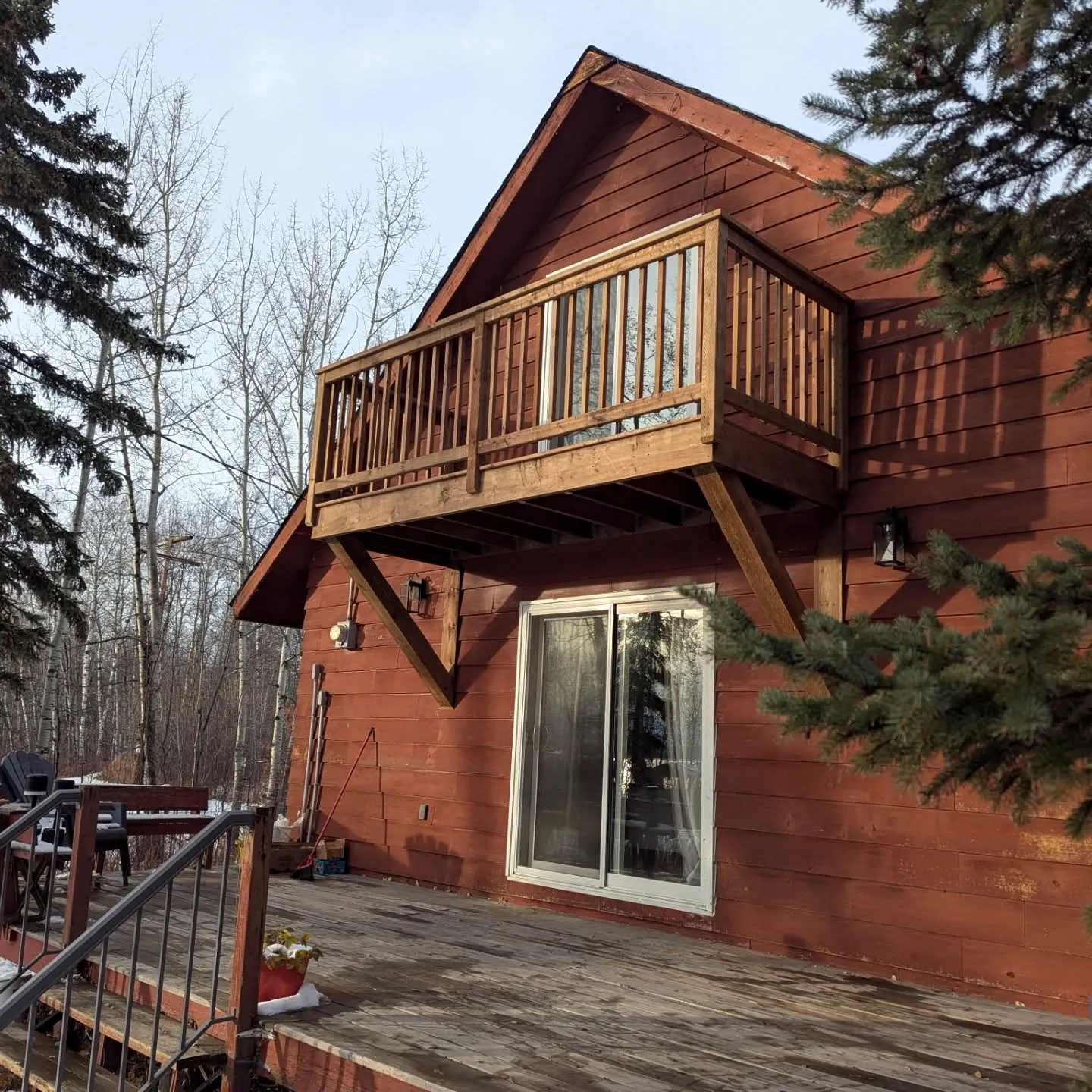 Cantilevered balcony on a red A-frame cabin