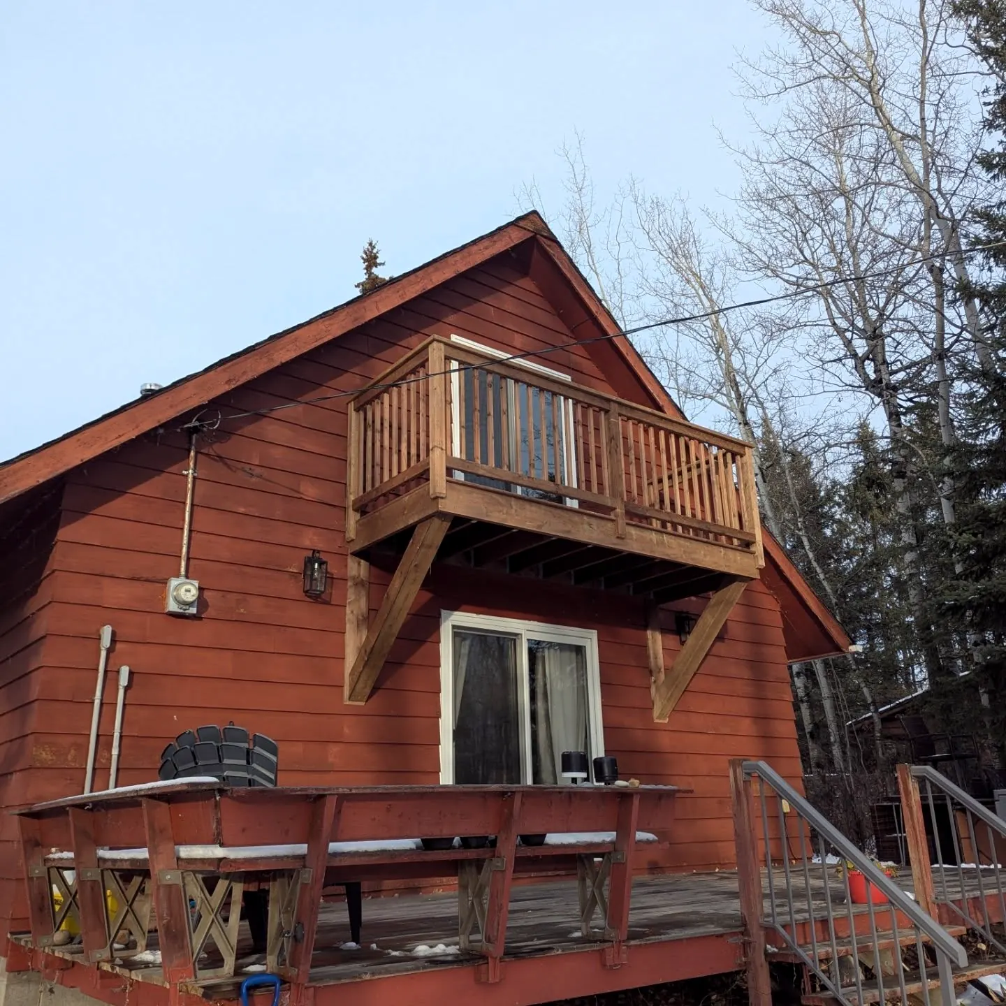 Balcony with knee braces on a red cabin