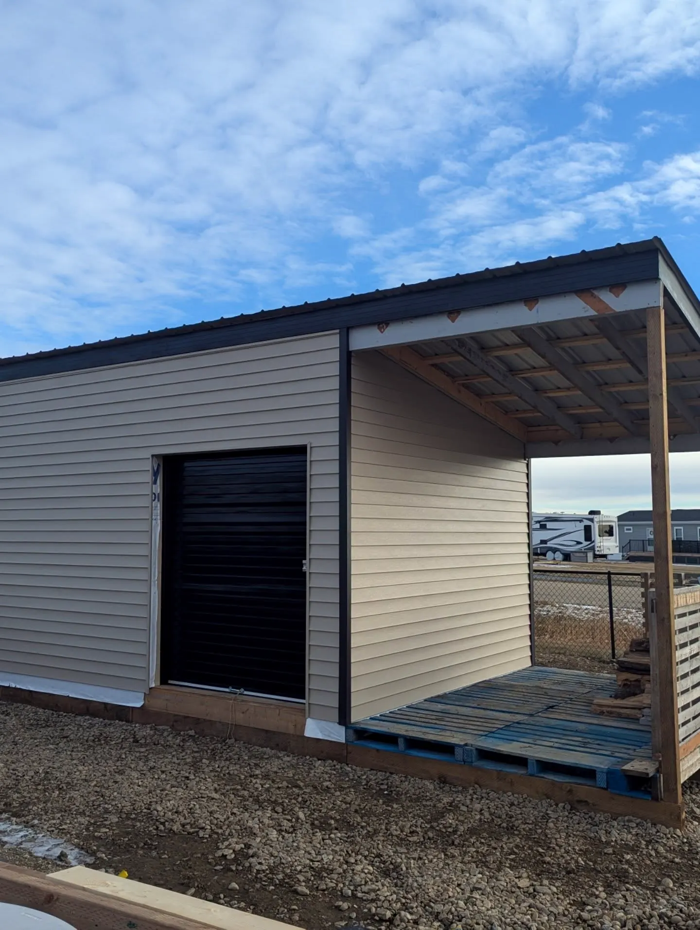 Small outbuilding with new siding and a covered porch