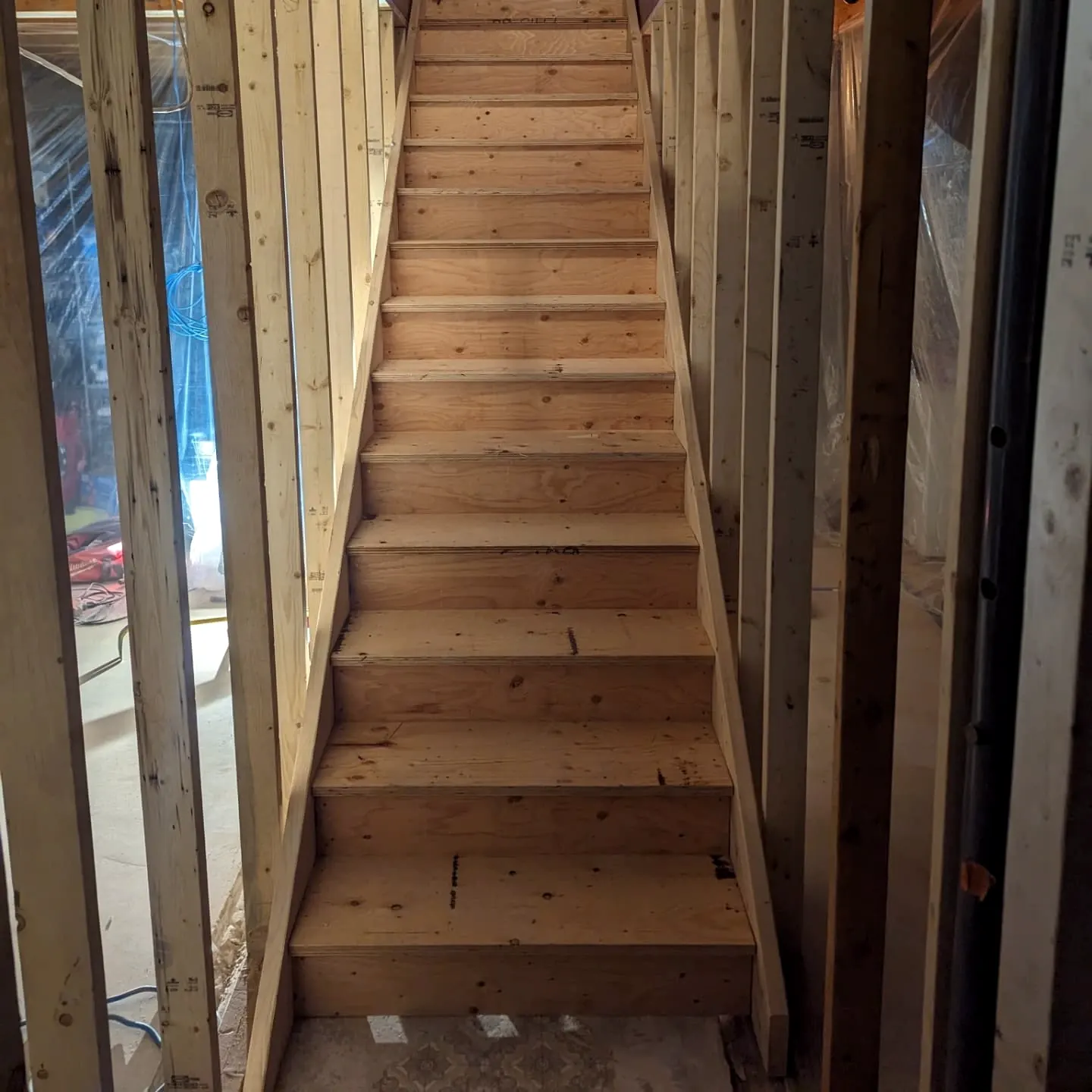 Wood staircase between framed walls
